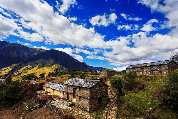 The photo is clicked while on a trek to mysterious skeletal lake of Roopkund in Uttarakhand province of India. The village visible in image is Didna or Didina village, a settlement of nearly 15 houses that has few farms and cattle grazing patches. The village has no road connectivity and no electricity connectivity. 