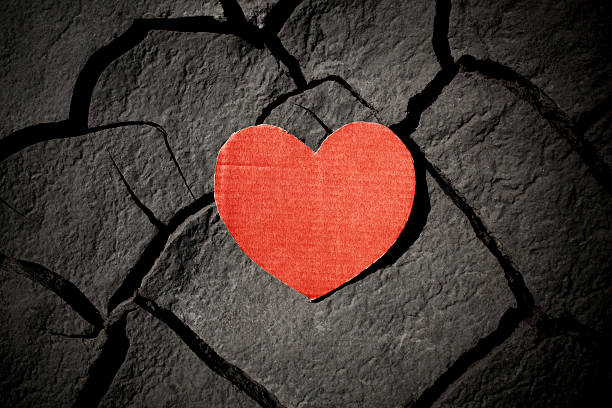 istock paper red heart on cracked earth 473176312