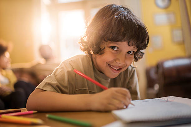 istock Cute African American boy drawing with crayons at home. 473179566