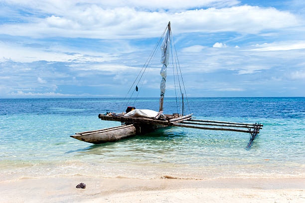 istock Old outrigger canoe on a shore of a white sand beach 473181326