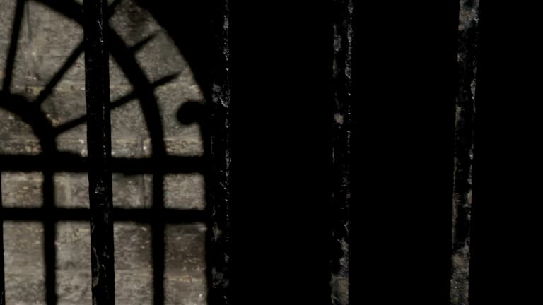 Black metal bars on a cold stone prison cell