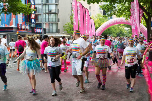 Seattle, Washington, USA - May 10, 2015:  Participants are having fun and running or walking in The Color Run, an annual Fun Run Event held in cities around the world.  A male entrant looks back over his shoulder to check on the status of a racing companion.