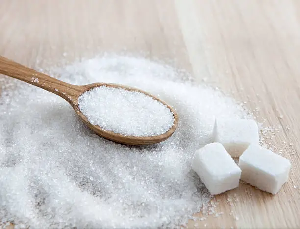 Photo of Sugar on wooden table. Selective focus