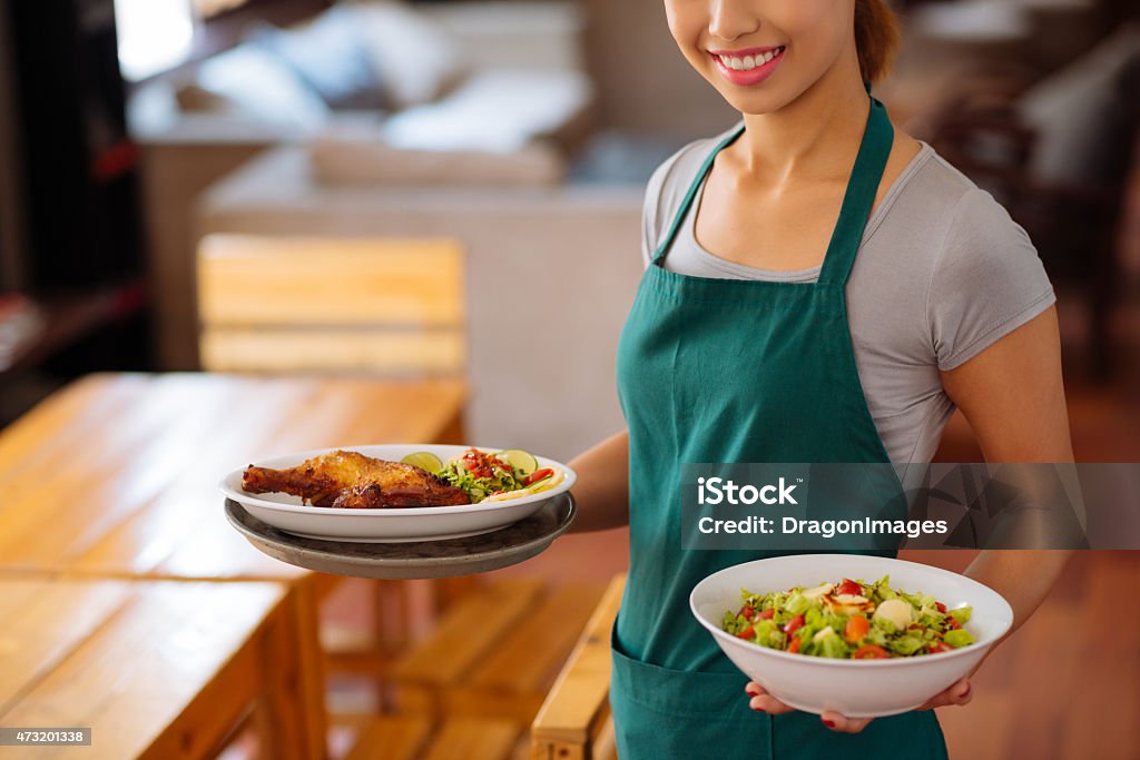 Serving food Cropped image of waitress serving food in a cafe Serving Food and Drinks Stock Photo