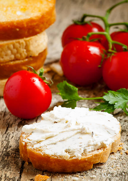 istock Home crostini with soft cheese and tomatoes on wooden table 473204578