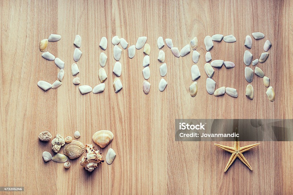 Sea shells and starfish on wooden table Sea shells and starfish on wooden table. With shells written word summer 2015 Stock Photo