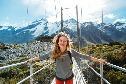 Beautiful girl on a swing bridge on the Hooker Valley trail on the South Island of New Zealand. 