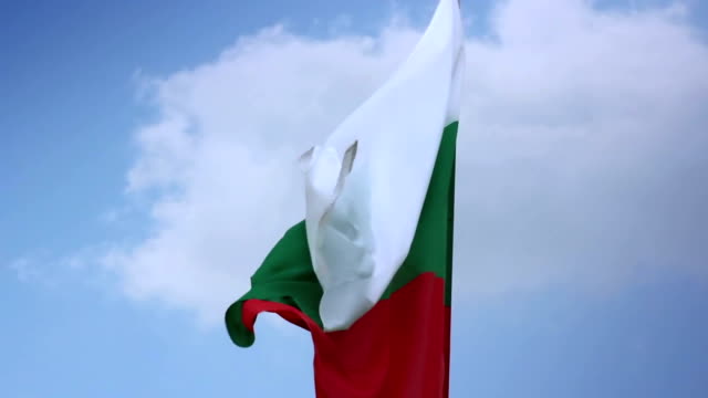 Bulgarian national flag waving on flagpole in blue sky. Bulgaria