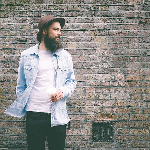 Portrait of a bearded man on brick wall background.