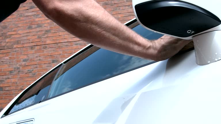 Man Polishing A Car Window