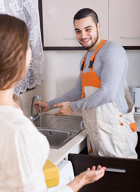 istock Repairman and housewife at kitchen 473237616