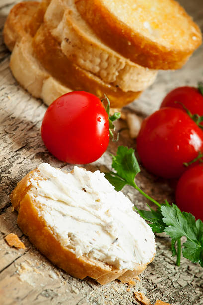 istock Home crostini with soft cheese and tomatoes on wooden table 473243684