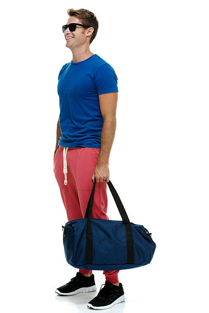 istock Smiling casual man holding duffle bag 473246336
