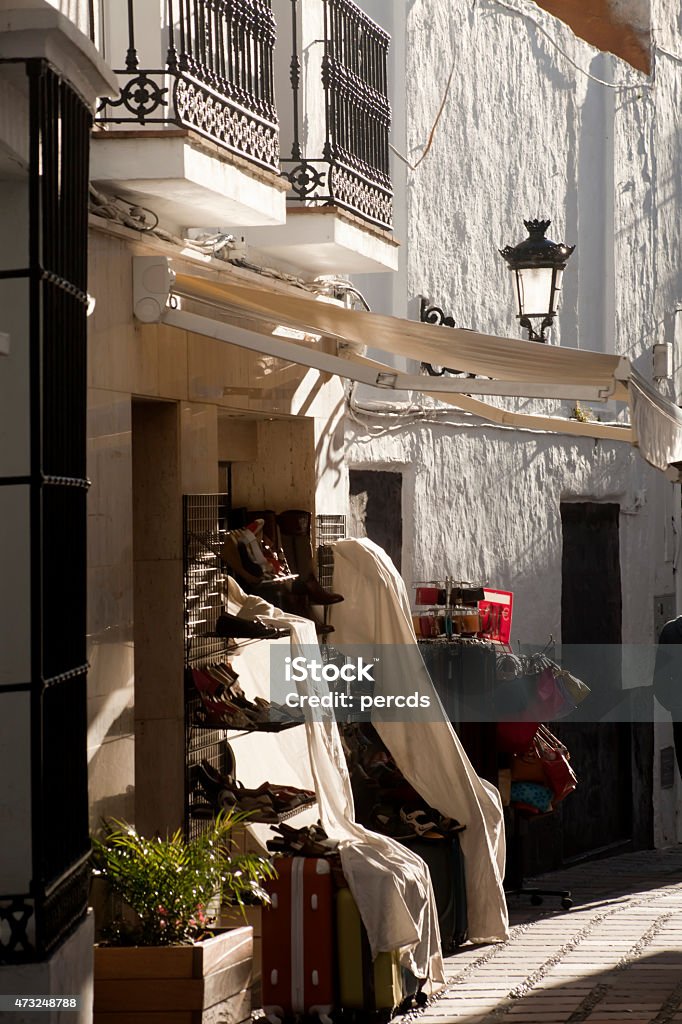 Traditional old town street, Marbella, Málaga, Spain Traditional narrow old town street in the sun light, white walls and shoe shop in Marbella, Málaga, Andalucia, Spain Business Stock Photo