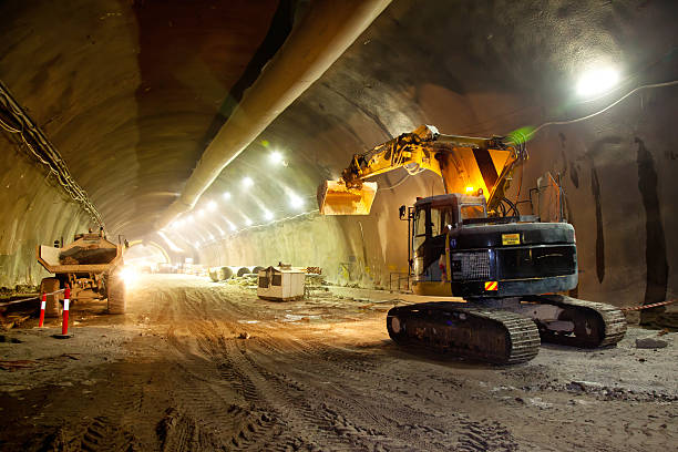 Concrete Road Tunnel Construction Excavator Concrete Road Tunnel Construction Excavator and Articulated Dump Truck construction equipment stock pictures, royalty-free photos & images