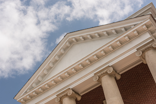 A detail view of an academic building of neoclassical proportions and style in an american university campus. Symbols of tradition stability, it could also be a bank a financial institution or a curt house. The actual portico is located at Mary Washington University in Fredericksburg, Virginia, USA.