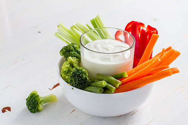 Vegetable sticks (pepper, celery, carrot, broccoli) in white bowl Vegetable sticks (pepper, celery, carrot, broccoli) in white bowl and yogurt, white wood background dipping sauce stock pictures, royalty-free photos & images
