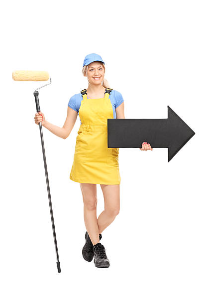istock Female painter holding a paint roller and an arrow 473265410