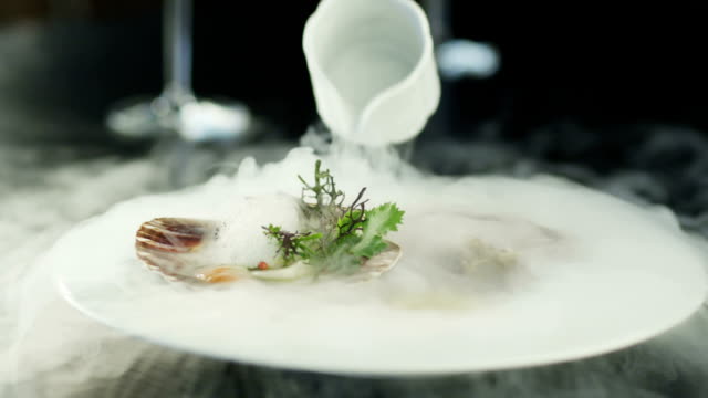 Chef Garnishing Scallops with Dry Ice in Luxury Restaurant.