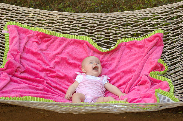 Baby girl on a blanket on a hammock stock photo