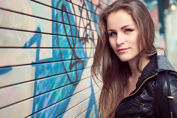 istock Young and beautiful girl posing against graffiti wall 473272708