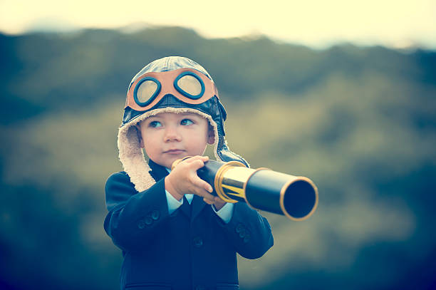 istock Young boy in a business suit with telescope. 473284370