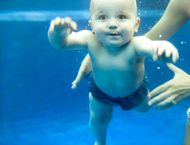Baby underwater Baby boy swimming underwater of swimming pool immersed in their work stock pictures, royalty-free photos & images