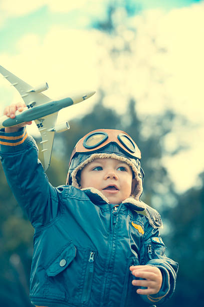 istock Young boy with a aviator outfit and airplane. 473286262
