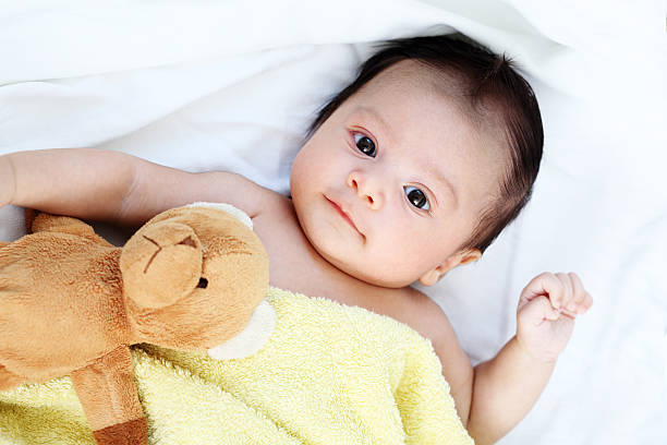istock Cute baby is yellow blankets prepare sleeping with bear doll 473286898