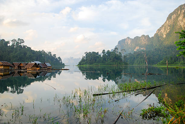 istock Tropical lakeside hut and wooden boat 473289502