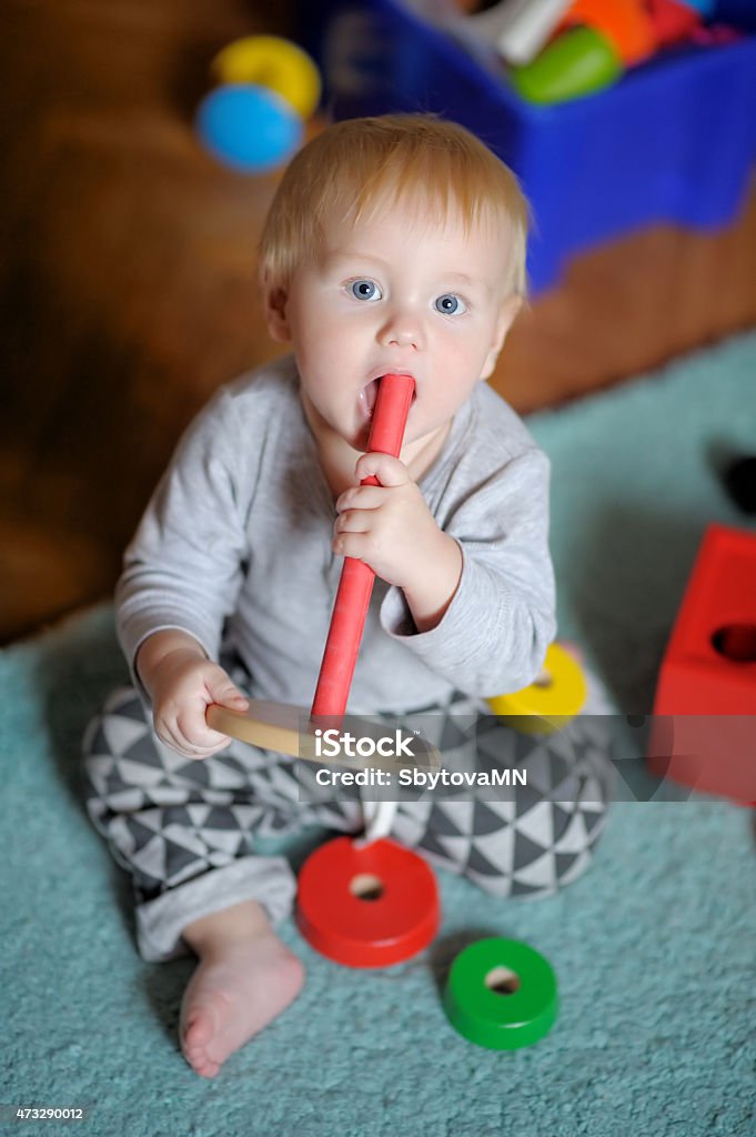 Baby playing with toy Little baby boy playing with bright toy 12-17 Months Stock Photo