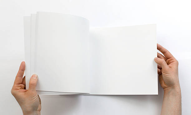 istock Flipping through a blank brochure in front of a white background 473292918