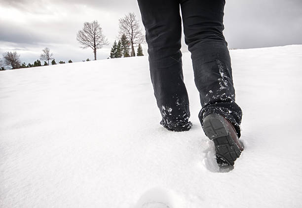 istock foot steps walking at snow in winter 473293300