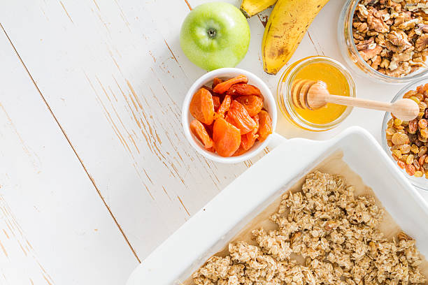 istock Preparing granola - granola mix in baking form, banana, apples 473293518