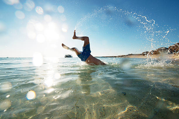istock Playful man having fun in the sea during summer day. 473294532