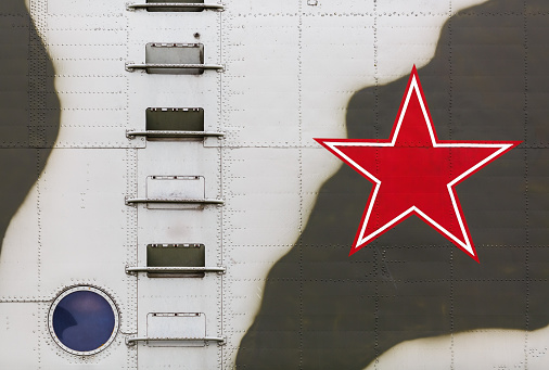 A large fragment of the old Soviet military helicopter. Red Star on board, ladder and round window.