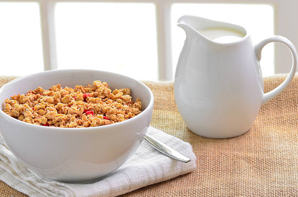 istock Breakfast Muesli cereal clusters with a jug of fresh milk. 473299550