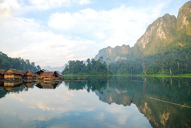 istock Tropical lakeside hut and wooden boat 473300262