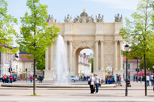 Potsdam,Germany - May 3, 2015: The famous Brandenburger Tor on Louisenplatz in Potsdam, Germany. This Gate  was erected in 1770 and is situated close to Schloß Sanssouci. Lots of tourists are strolling around it. Potsdam is situated next to the german capital, Berlin.