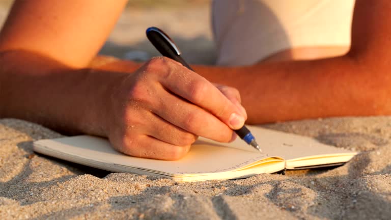 Man writing in his diary at the beach