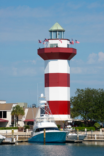Hilton Head, South Carolina, USA - September 22, 2014: Boats are docked in front of the landmark red and white lighthouse at Harbour Town in Hilton Head, South Carolina