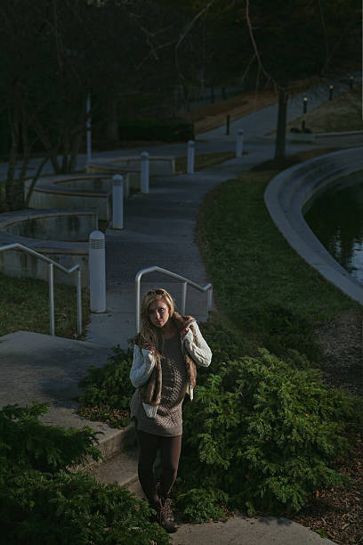 istock young female standing in city park late evening 473308052