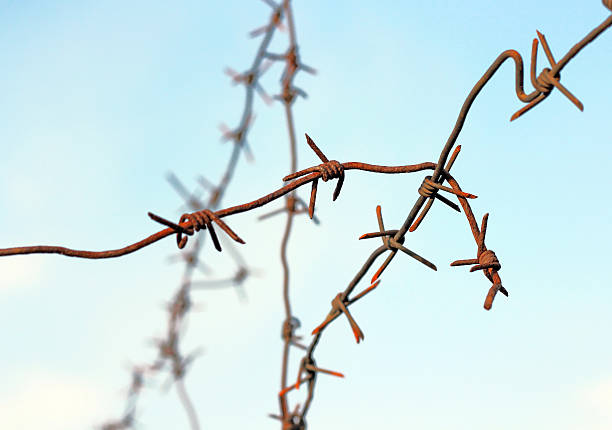istock barbed wires against blue sky 473308134