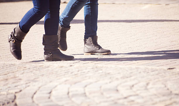 istock pedestrians legs walking on the sidewalk 473308536