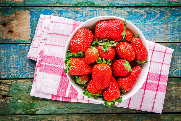 istock Fresh ripe organic strawberries in a white bowl top view 473309162