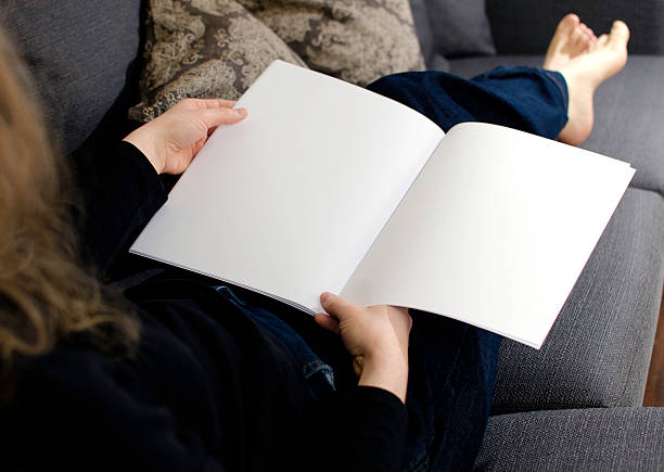 istock Woman resting on couch looking at blank pages 473309206