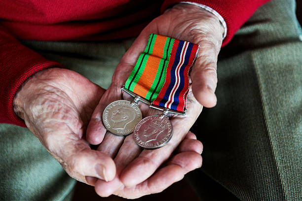 istock Old Soldier Holding His War Service Medals. 473309462