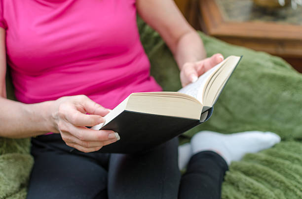 istock Woman reading a book on a couch 473309988