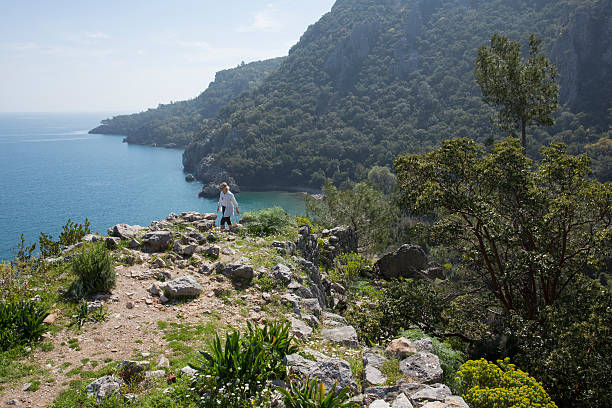 istock Hiker ascends mountain ridge crest above sea 473312488