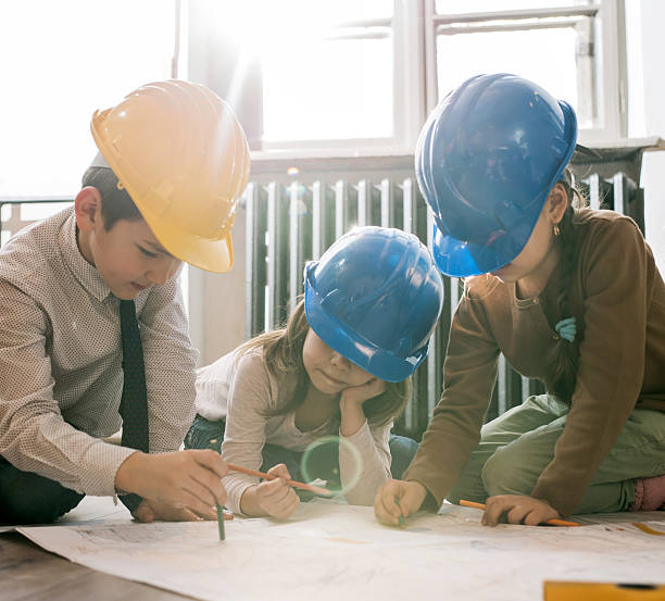 istock Team of little engineers working on blueprints together. 473313208